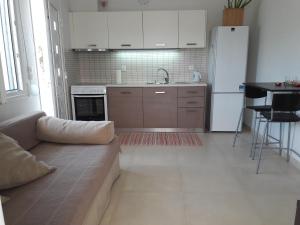 a kitchen with a couch and a white refrigerator at Afroessa Studios & Apartments in Samos