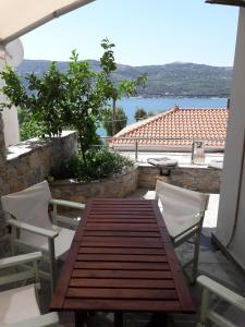 uma mesa e cadeiras de madeira com vista para a água em Afroessa Studios & Apartments em Samos
