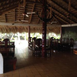 ein Zimmer mit Stühlen und Tischen in einem Gebäude in der Unterkunft Playa Paraiso en Magante in La Yagua