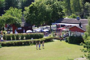 two people standing in a field in front of a building at Rösjöbaden Camping & Stugby in Sollentuna