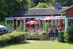 een groep mensen die buiten een bar zitten bij Rösjöbaden Camping & Stugby in Sollentuna