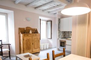 歐蘇西奧的住宿－La Casa di Celeste，厨房以及带桌椅的起居室。