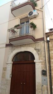 a building with a wooden door and a balcony at Almasol in Cassano delle Murge