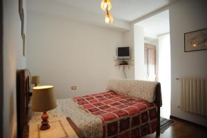 1 dormitorio con 1 cama y 1 mesa con lámpara en Agriturismo Stella Orobica, en Albosaggia