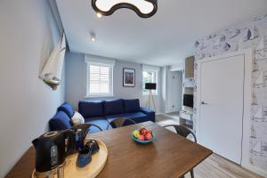a living room with a blue couch and a table at Victus Apartamenty, Apartamenty Delux in Sopot