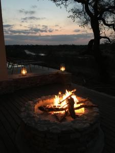 a fire pit with a person sitting around it at Manzini River House in Hectorspruit