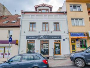 two cars parked in front of a building at Apartamenty Kamienica in Mrągowo