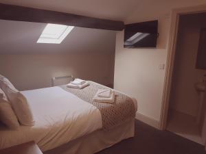 um quarto com uma cama com toalhas em The Moseley Arms em Birmingham