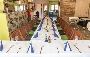 a long table in a room with blue bows at Penzion Podyjí in Znojmo