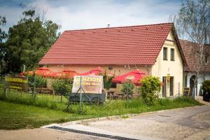 a building with a red roof and red umbrellas at Penzion Podyjí in Znojmo