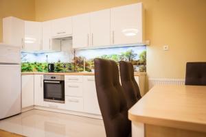 a kitchen with white cabinets and a table and chairs at Czar Garbar in Poznań