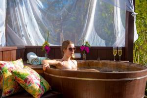 a woman is sitting in a hot tub at Pousada Terras Altas in Visconde De Maua