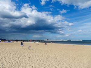 ソポトにあるBeach Apartment I Plażowy Happy Hoursの砂浜を歩く人々
