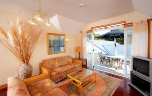 a living room with a couch and a tv and a table at Seaport Village in Russell