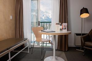 ein Hotelzimmer mit einem Tisch und einem Fenster in der Unterkunft Coast Canmore Hotel & Conference Centre in Canmore