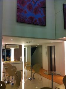a room with chairs and tables and a tv on the wall at Nantra Ekkamai Hotel in Bangkok +43 photos