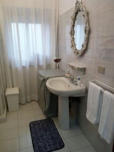 a white bathroom with a sink and a mirror at Borgo Zaccanazzo in Acireale