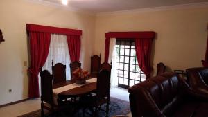 a dining room with a table and red curtains at Casa Deus in Sabrosa