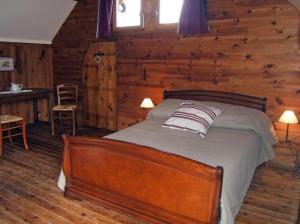 a bedroom with a bed in a log cabin at Ferme de la Cacheterie, in Fleury-la-Forêt +11 photos