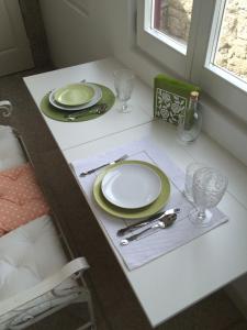 una mesa con platos verdes y blancos y cubiertos en GET a unique and luxury flat en Oporto