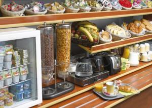 a shelf filled with food and other food items at Hôtel Akena City Albi Gaillac in Brens
