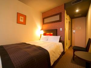 ein Hotelzimmer mit einem Bett und einem Tisch in der Unterkunft Hotel Pearl City Akita Kawabata in Akita