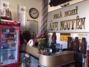 a shop with a refrigerator and a clock on the wall at Anh Nguyen Guesthouse in Pleiku