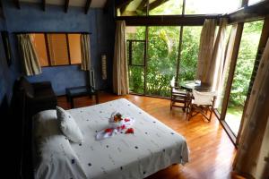 Tenorio Lodge في بيجاغوا: غرفة نوم بسرير وطاولة وكراسي
