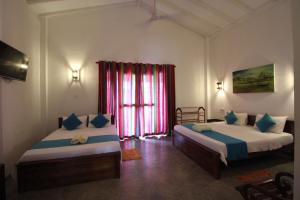 a bedroom with two beds and a window at Santori Unawatuna in Unawatuna