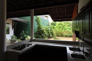 a kitchen with a stove top oven next to a window at Santori Unawatuna in Unawatuna