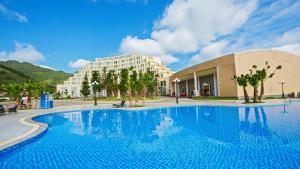 a large swimming pool in front of a building at Muong Thanh Holiday Moc Chau Hotel in Mộc Châu