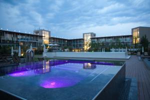 a large swimming pool with purple lights in front of a building at Aqualux Hotel Spa & Suite in Bardolino
