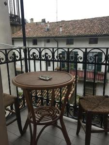 a table and chairs on a balcony with a view of a building at Lalla's Central Apartment in Tortona