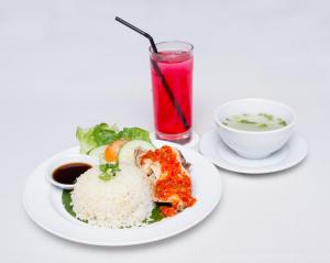 a white plate of food with rice and a drink at Hotel Seri Malaysia Seremban in Seremban