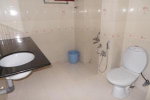 a bathroom with a toilet and a sink at Hotel Span in Kozhikode