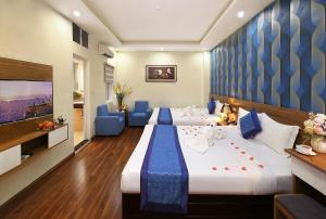 a hotel room with two beds and a flat screen tv at Aquarius Grand Hotel in Hanoi