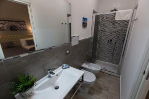 bagno con lavandino, servizi igienici e specchio di Casantò guest home a Palermo