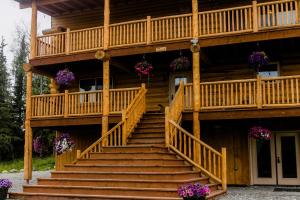 ein großes Holzhaus mit Treppen und Blumen in der Unterkunft Alaska Knotty Pine B&B in Palmer