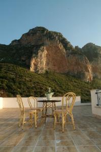 a table and chairs on a patio with a mountain at Torre Salina in Macari