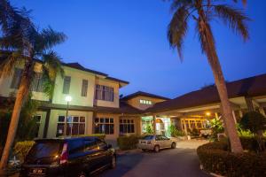 雪邦的住宿－馬來西亞甘邦甘拉朗謝麗酒店，棕榈树屋前的停车场