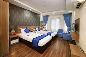 a hotel room with two beds and a couch at Aquarius Grand Hotel in Hanoi