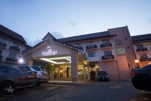 Hotel Seri Malaysia Kuala Terengganu في كوالا ترغكانو: فندق فيه سيارات متوقفة في مواقف