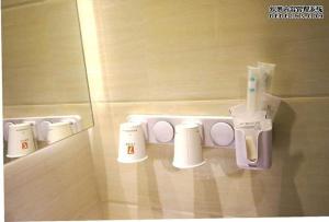 a bathroom with a shelf with cups and toothbrushes at 7Days Premium Zhangye Passengers Station in Zhangye