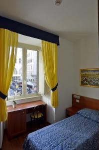 a bedroom with a bed and a desk and a window at Hotel Tex in Rome