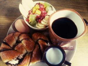 a plate of breakfast food with a cup of coffee and a croissant at Kiwi Backpackers Hostel Pokhara in Pokhara