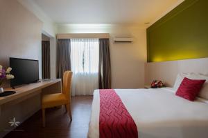 a hotel room with a bed and a desk with a computer at Hotel Seri Malaysia Pulau Pinang in Bayan Lepas