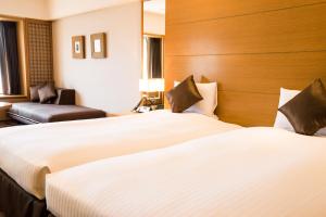 Postel nebo postele na pokoji v ubytování Kyoto Brighton Hotel