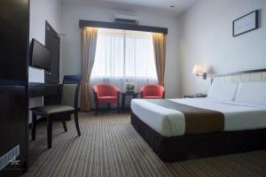 a hotel room with a bed and a desk and chair at Hotel Seri Malaysia Kepala Batas in Kepala Batas