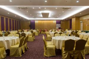 un salón de banquetes con mesas blancas y sillas amarillas en Hotel Seri Malaysia Kepala Batas, en Kepala Batas