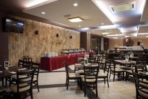 uma sala de jantar com mesas e cadeiras e uma parede em Hotel Seri Malaysia Kepala Batas em Kepala Batas
